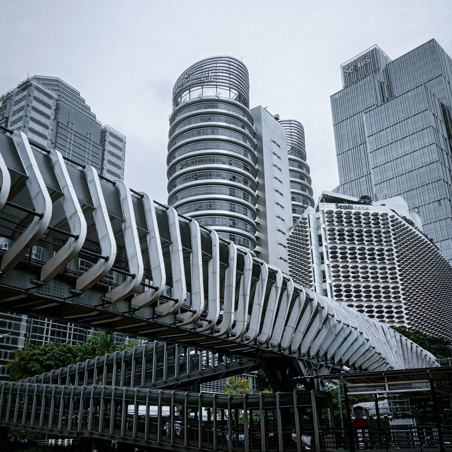 Futuristic elevated pedestrian bridge with modern high-rise architecture in an urban district